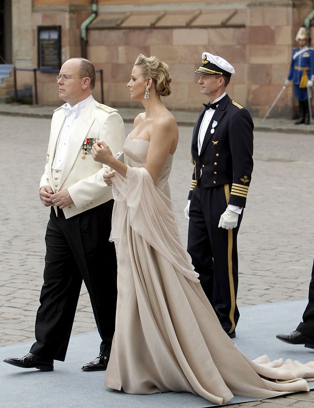 El Príncipe Alberto de Mónaco, con chaqueta blanco, y su bella novia Charlene Wittsotck con un vestido palabra de honor en color "nude" y chal del mismo tono.