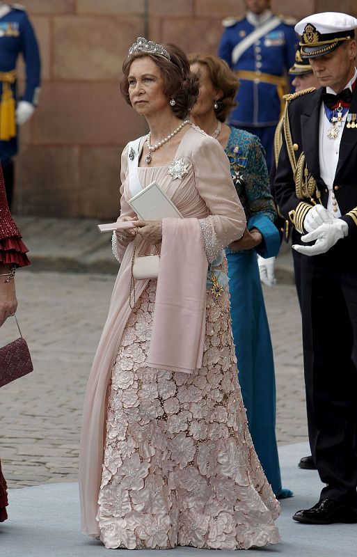 La Reina ha lucido unos pendiente de perlas en forma de lágrimas y pendientes también de perlas.