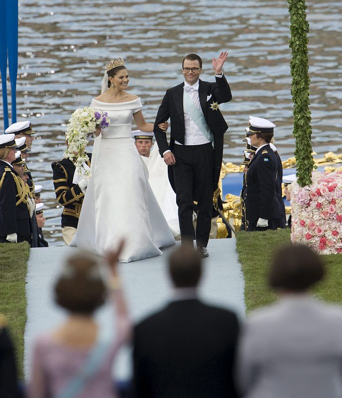 Los recién casados saludan a los invitados, que les reciben entre aplausos.