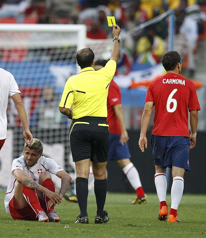 Referee Khalil Al Ghamdi of Saudi Arabia flashes the yellow card to Chile's Carlos Carmona during the 2010 World Cup Group H match against Switzerland at Nelson Mandela Bay stadium in Port Elizabeth