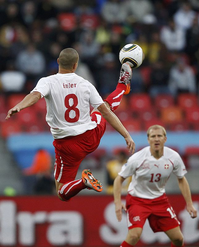 Switzerland's Grichting watches as Inler kicks ball during a 2010 World Cup Group H match against Chile in Port Elizabeth