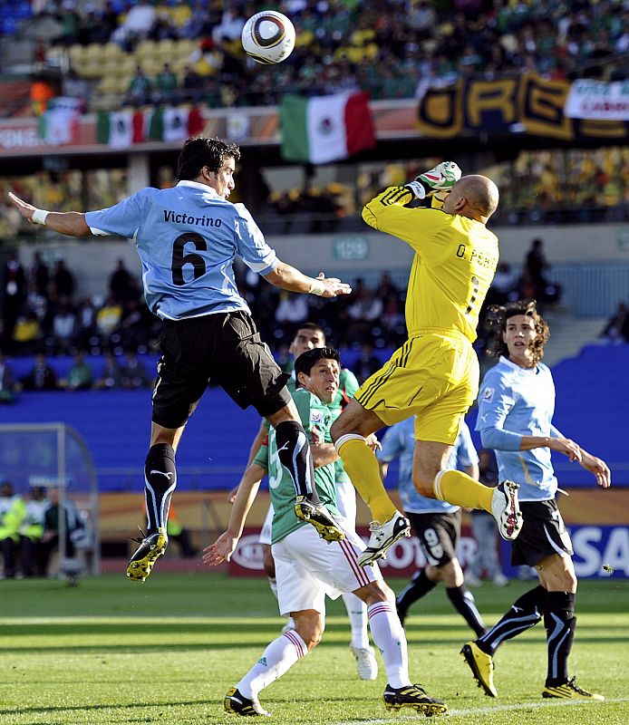 El delantero mexicano Óscar Pérez pugna por un balón con el portero de Uruguay, Victorino.