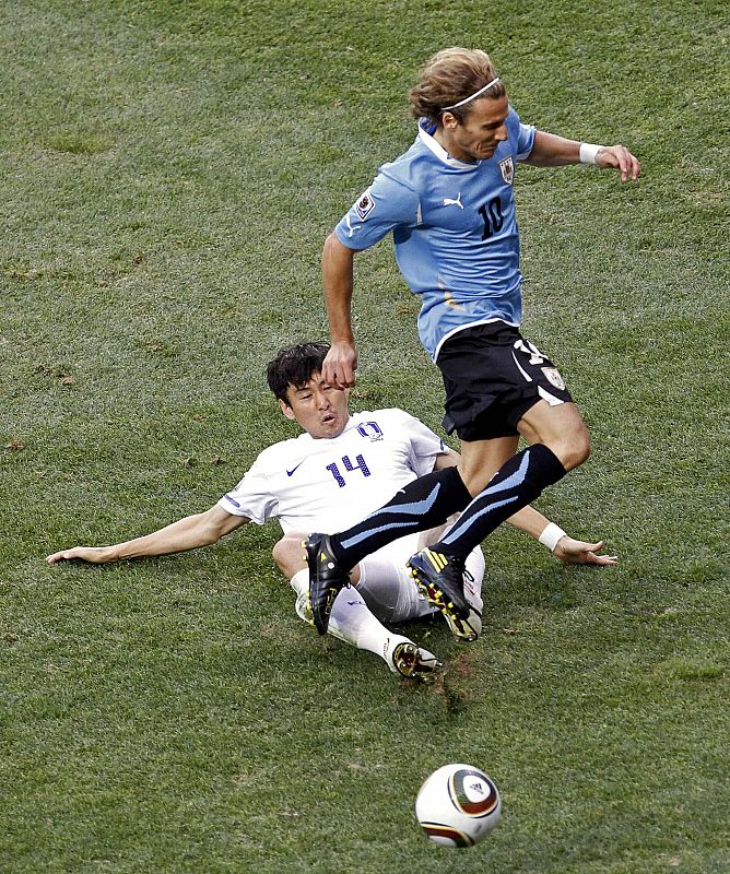 Diego Forlan se marcha con el balón controlado ante la presión de Lee Jung-soo