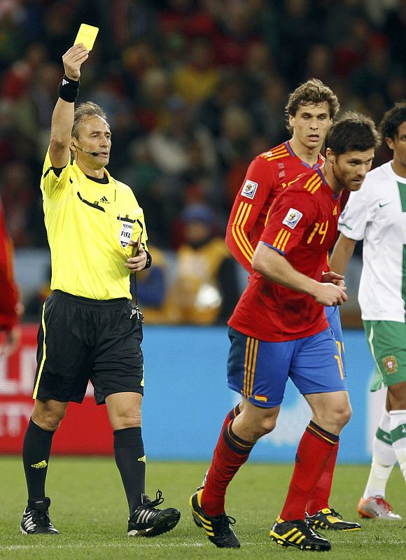 Referee Baldassi shows the yellow card to Spain's Alonso after a foul during the 2010 World Cup second round soccer match against Portugal in Cape Town