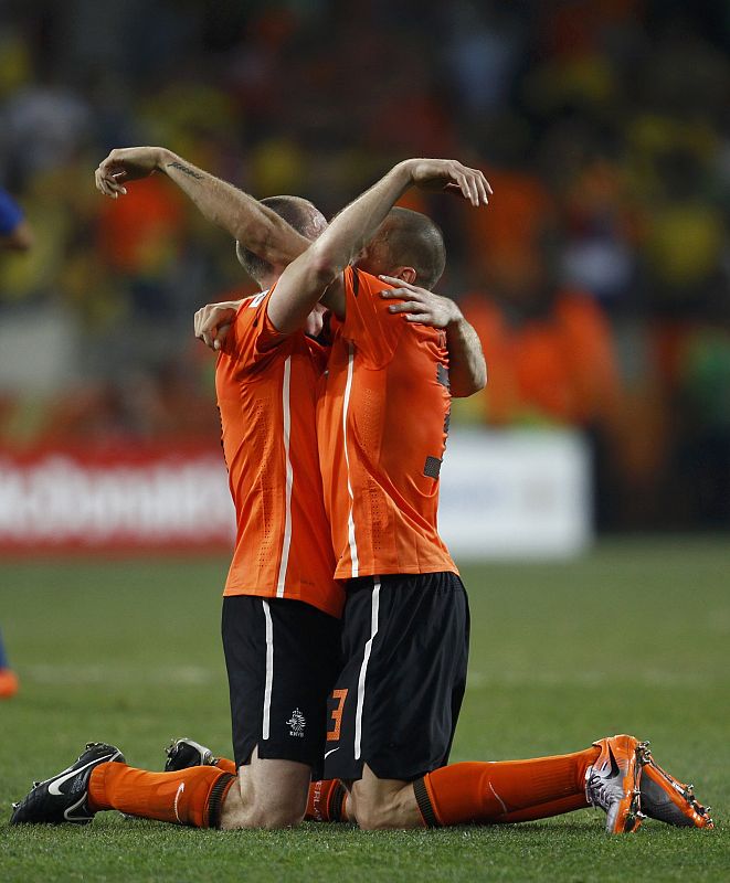 Netherlands' Andre Ooijer celebrates with John Heitinga after the 2010 World Cup quarter-final soccer match between Netherlands and Brazil in Port Elizabeth