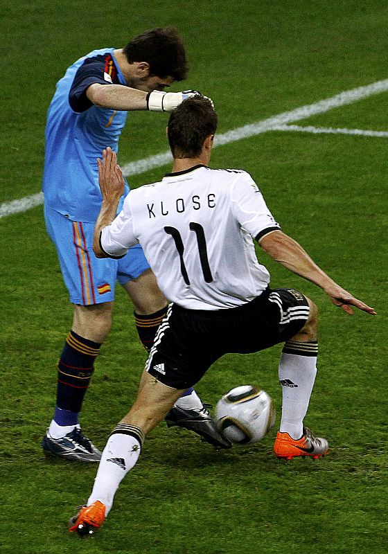 Spain's goalkeeper Casillas kicks the ball as Germany's Klose challenges during their 2010 World Cup semi-final soccer match at Moses Mabhida stadium in Durban