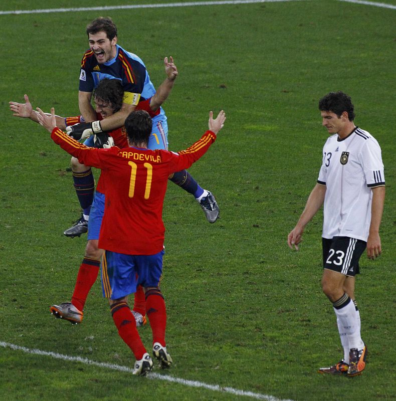 Spain's players celebrate near Germany's Gomez at the end of their 2010 World Cup semi-final soccer match in Durban