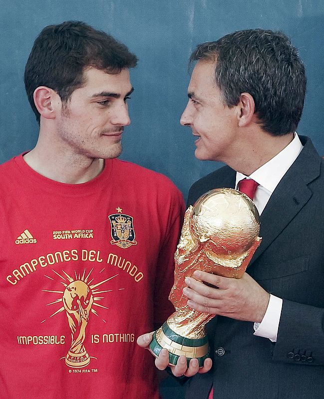 Zapatero coge el trofeo de la Copa del Mundo mientras dialoga con el portero Iker Casillas.