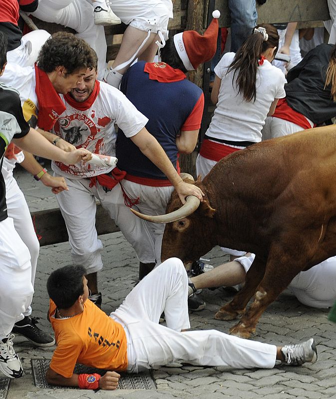 A woman runner is gored by a fighting bull during the ninth running of the bulls of the San Fermin festival in Pamplona