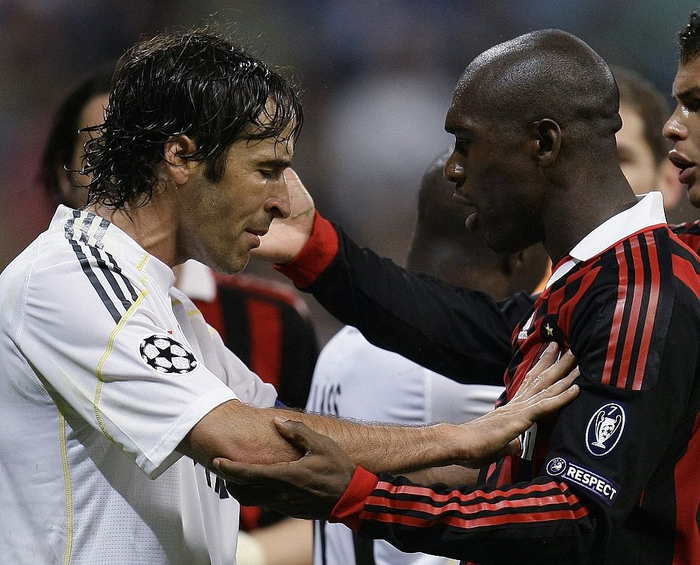 Raúl y Clarence Seedorf del AC Milan disputan durante un partido de fútbol Liga de Campeones en el estadio Santiago Bernabéu.