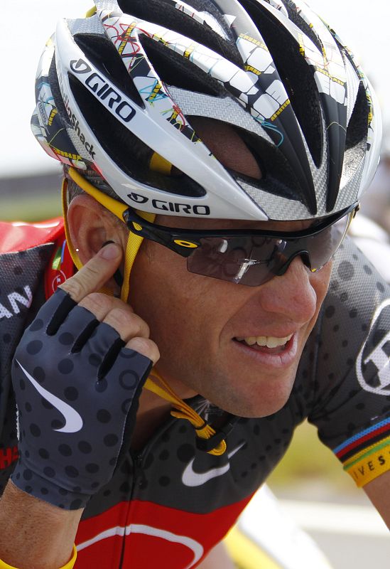 Armstrong adjusts his earphone as he cycles during the first stage of Tour de France race from Rotterdam to Brussels