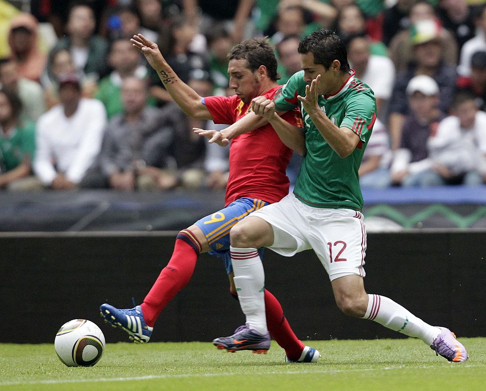 Cazorla disputa un balón con Aguilar.
