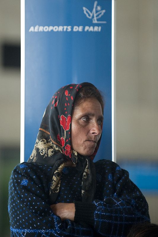 A Roma woman who participates in the voluntary repatriation scheme to Romania watis at Roissy Charles-de-Gaulle airport near Paris