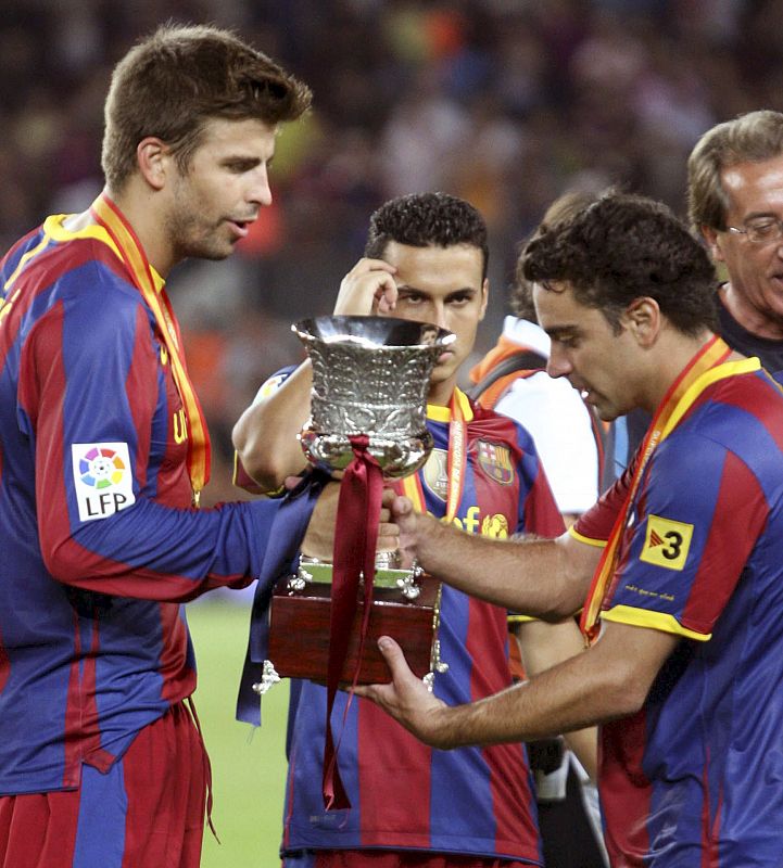 Gerard Piqué, Xavi Hernández y Pedro Rodríguez con el trofeo.