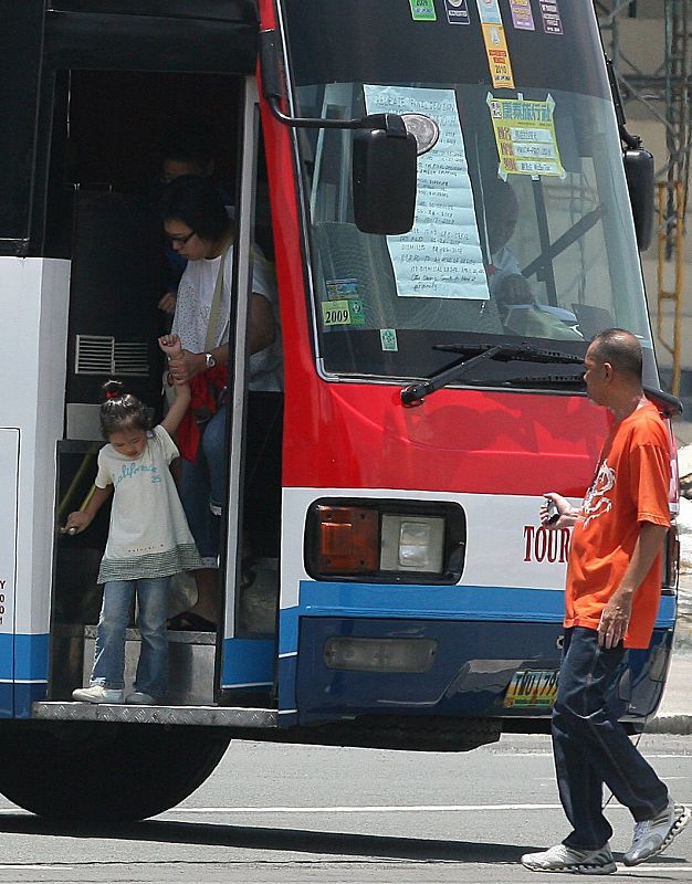 Un grupo de rehenes baja del autobús secuestrado po un ex policía este lunes en Filipinas.