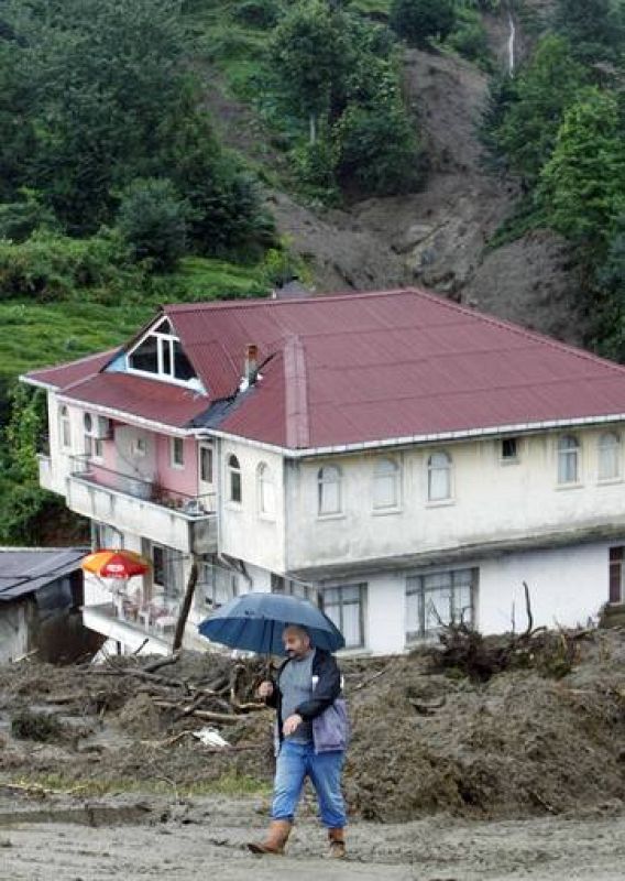 Un residente camina frente a uno de los edificios afectados por el desprendimiento de tierra en la localidad turca de Gundogdu. 