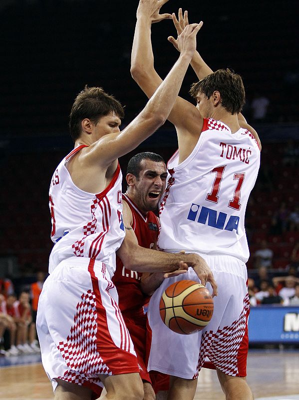 Veisi of Iran drives to the basket between Tomas and Tomic of Croatia during their FIBA Basketball World Championship game in Istanbul