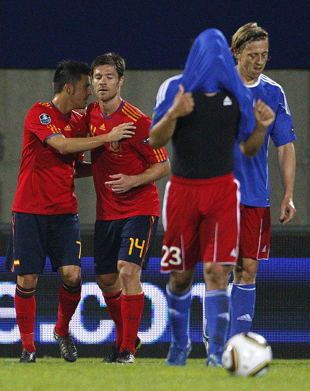 Liechtenstein's Polverino reacts as Spain's Villa and Alonso celebrate second goal during their Euro 2012 qualifying soccer match in Vaduz