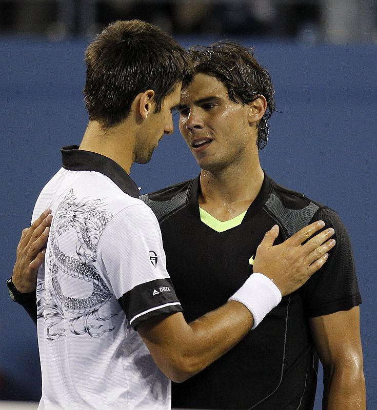 Djokovic y Nadal se abrazan tras finalizar el partido, después de seis horas, incluida una interrupción de dos horas por la lluvia, que volvió a hacer acto de presencia.