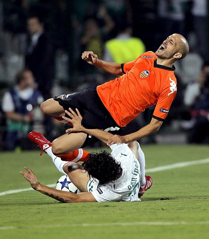 El jugador del Bursaspor Ozan Ipek (abajo) pelea por el control del balón con el jugador del Valencia, Bruno Saltor