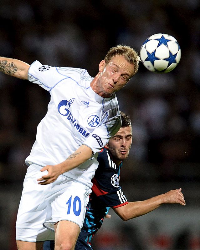 El jugador del Olympique de Lyon, Miralem Pjanic (dcha), pelea por el control del balón con el jugador del FC Schalke 04, Ivan Rakitic