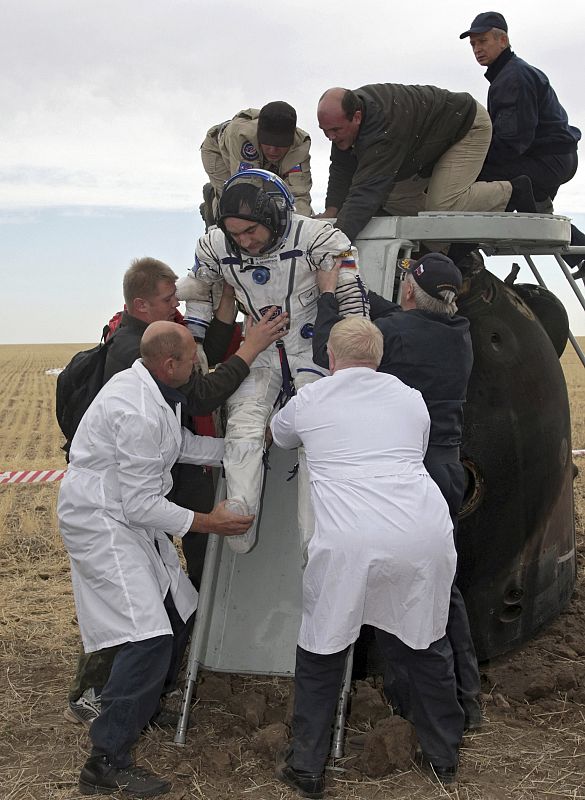 Specialists help Russian cosmonaut Skvortsov get out from the Soyuz TMA-18 spacecraft after landing near the town of Arkalyk