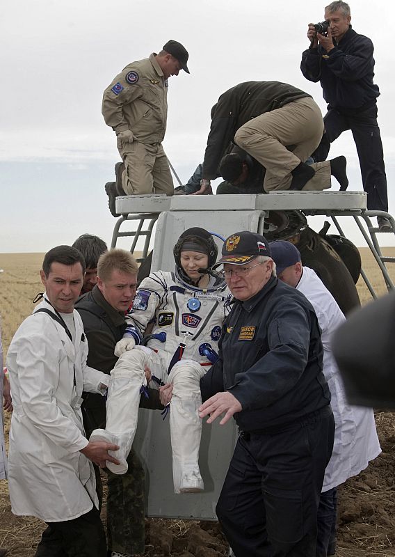 Specialists help U.S. astronaut Tracy Caldwell Dyson get out from the Soyuz TMA-18 spacecraft after its landing near the town of Arkalyk,