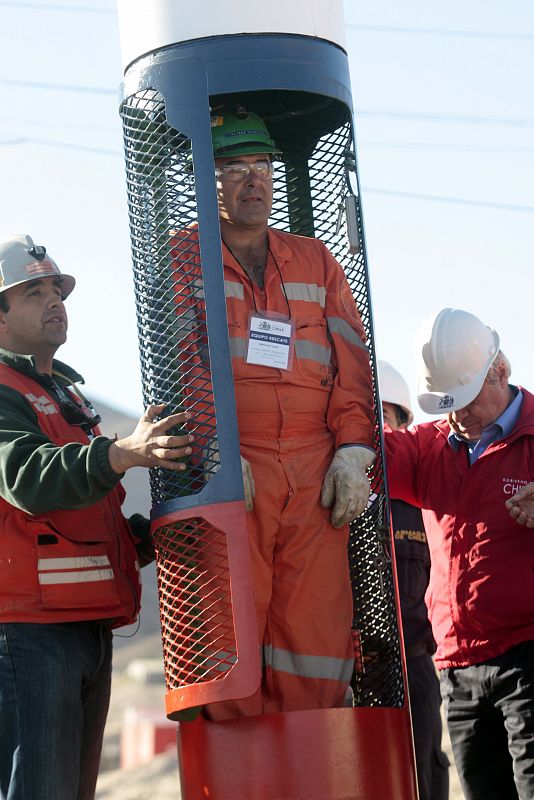 Uno de los trabajadores explica a los familiares y presentes cómo será el rescate