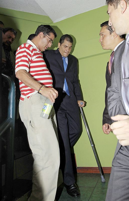 Rafael Correa, ayudado por su seguridad dentro de la sede de la Policía Nacional