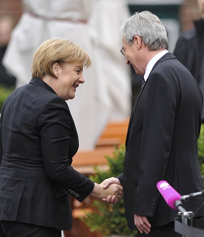 German Chancellor Merkel greets President of the Bundesrat Boehrnsen on arrival for church service marking country's 20th anniversary of reunification in Bremen