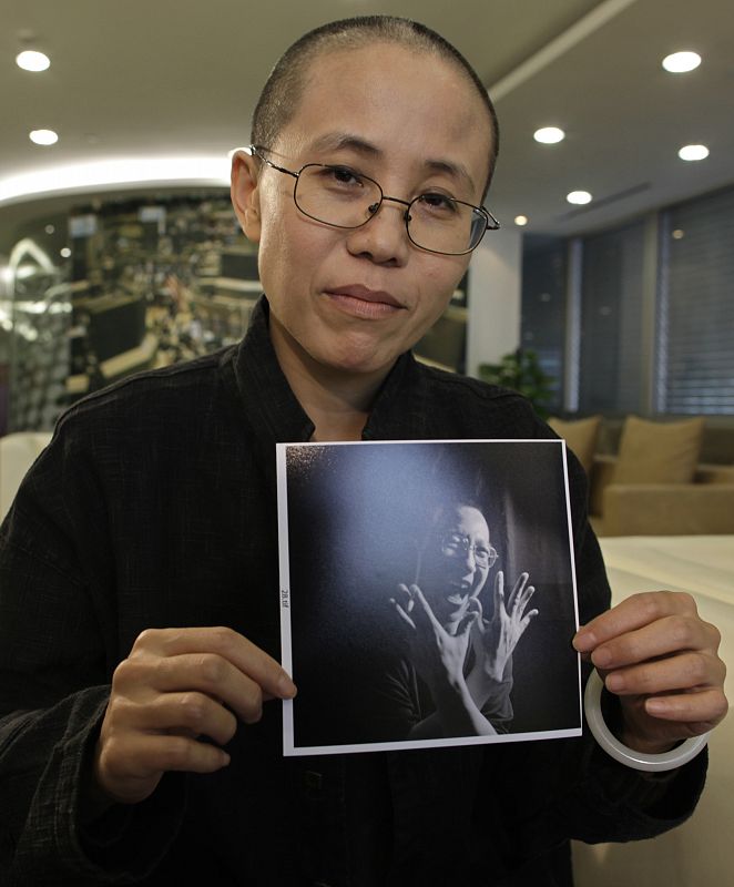 Liu Xia, the wife of Chinese dissident Liu Xiaobo, holds a photo of her husband during an interview in Beijing