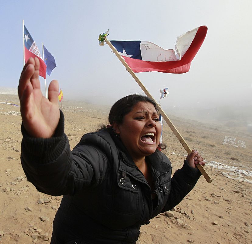 A relative of the 33 trapped miners reacts as she shouts slogans after the T 130 drilling machine completed an escape hole at San Jose mine near Copaipo city