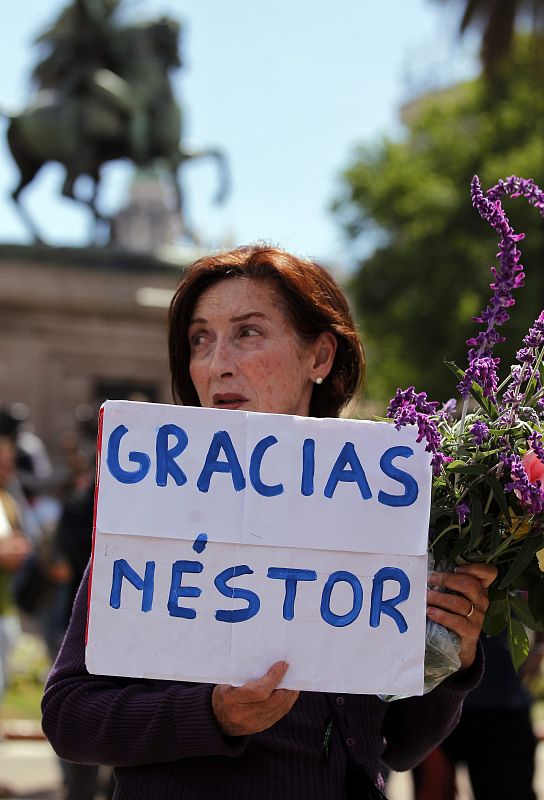 Una mujer sostiene una pancarta en la que agradece al ex presidente Kirchner su labor