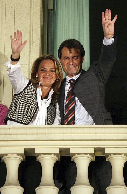 Leader of Catalonia's Convergencia i Unio Mas and his wife wave from the party headquarters in Barcelona