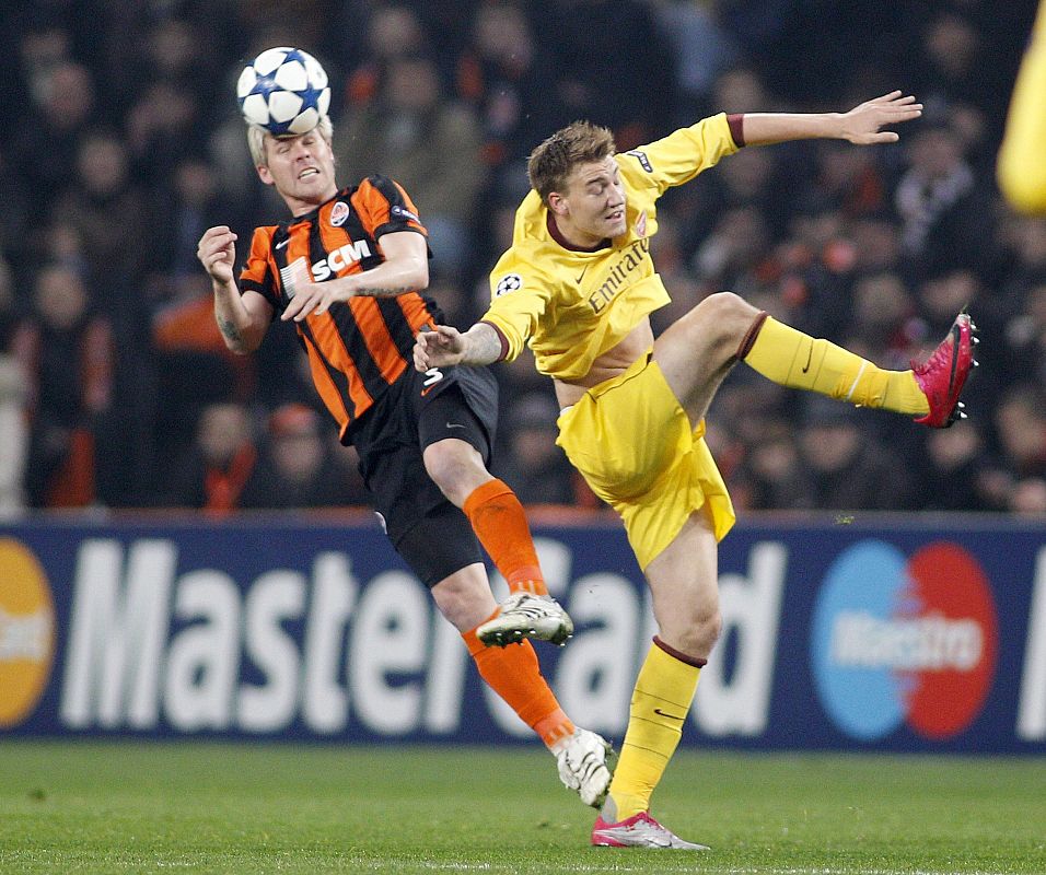 Hubschman, del Shakhtar, lucha con Bendtner, del Arsenal.