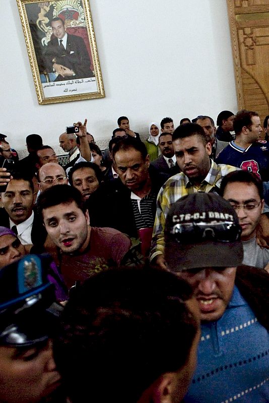 El periodista Eduardo Marín (izquierda) en el momento de su retención por parte de policías de paisano y rodeado por activistas marroquíes