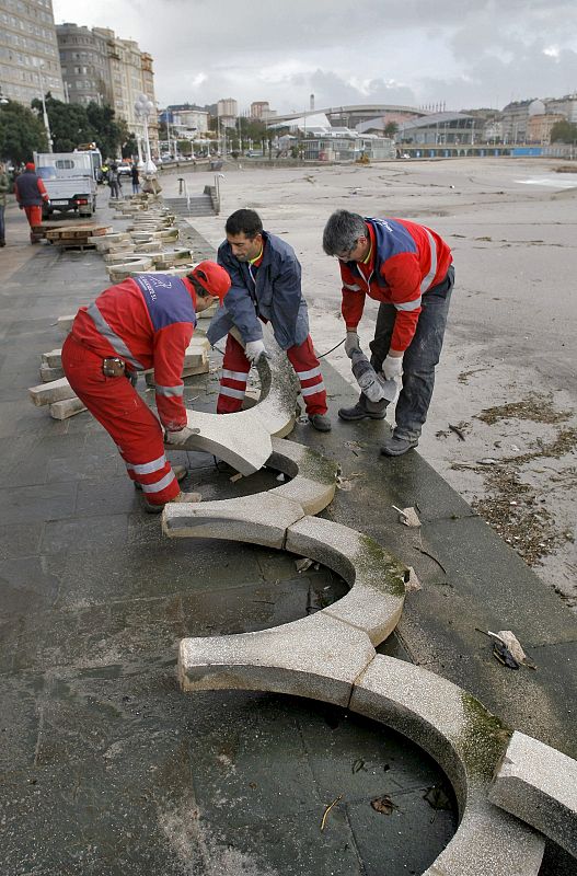 Los operarios trabajan en la reconstrucción de la balaustrada de piedra del paseo marítimo de A Coruña, de la que cayeron 100 metros debido al fuerte oleaje.