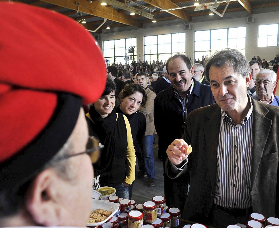 El candidato de CiU a la Generalitat de Cataluña, Artur Mas, degusta platos regionales tras el mitin que ofreció el domingo en Banyoles.