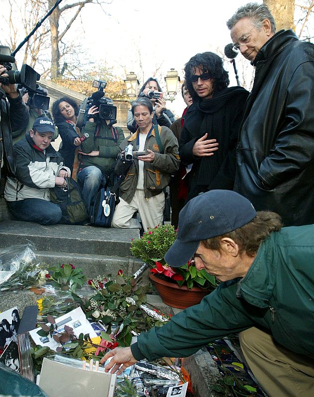 The seventies rock group The Doors' guitarist Robby Krieger (Bottom, R) kneels as he places a candle..