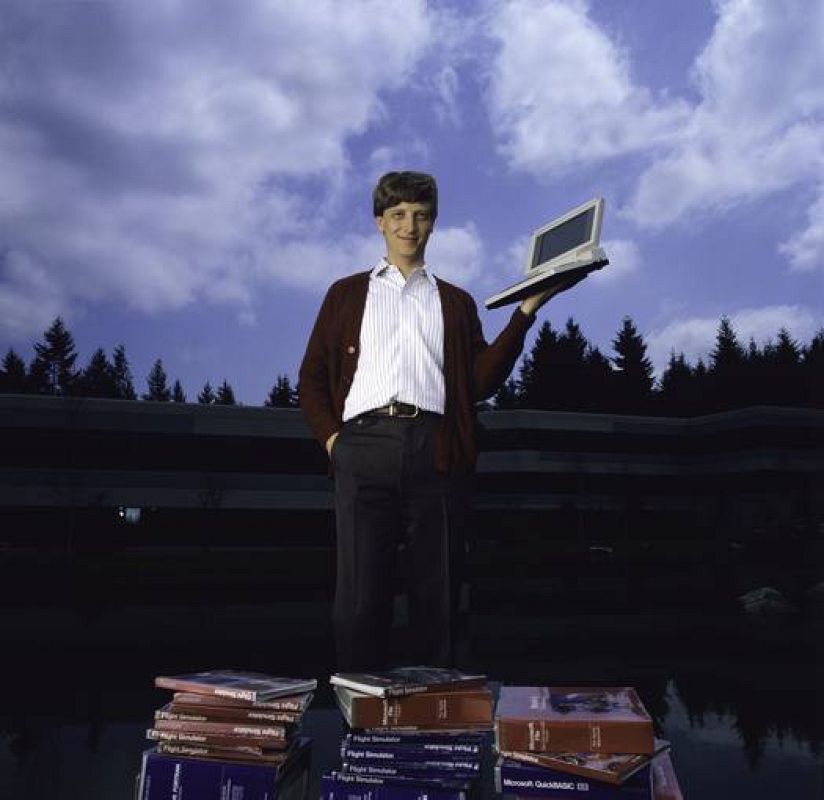 1986 - El cofundador de Microsoft posa con el primer portatil de la compañía. 