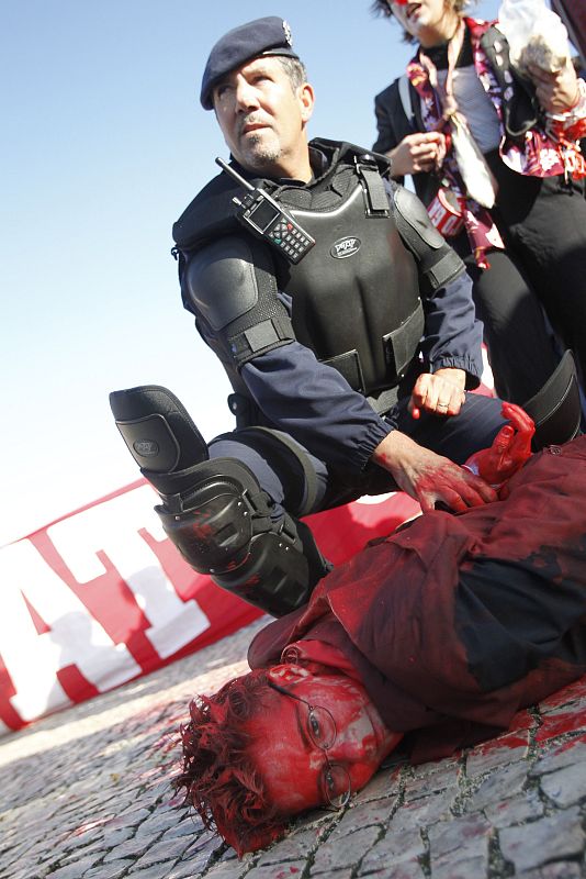 A person is tackled by police during a protests against the NATO summit in Lisbon