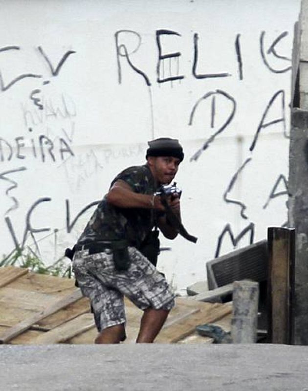 Un narcotraficante toma posiciones para disparar contra la policía. 