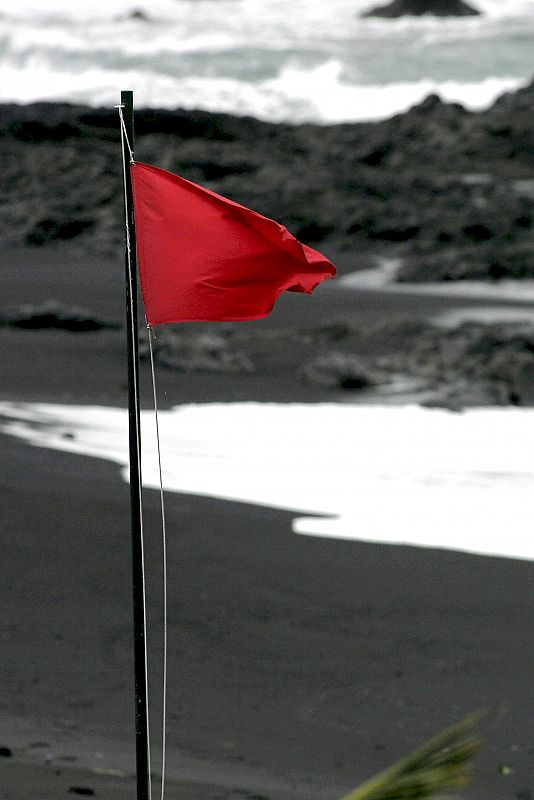 La bandera roja que prohíbe el baño, ondea en la playa de Punta Brava, en el Puerto de la Cruz (Tenerife), como consecuencia del temporal de viento que azota el archipielago canario desde anoche.