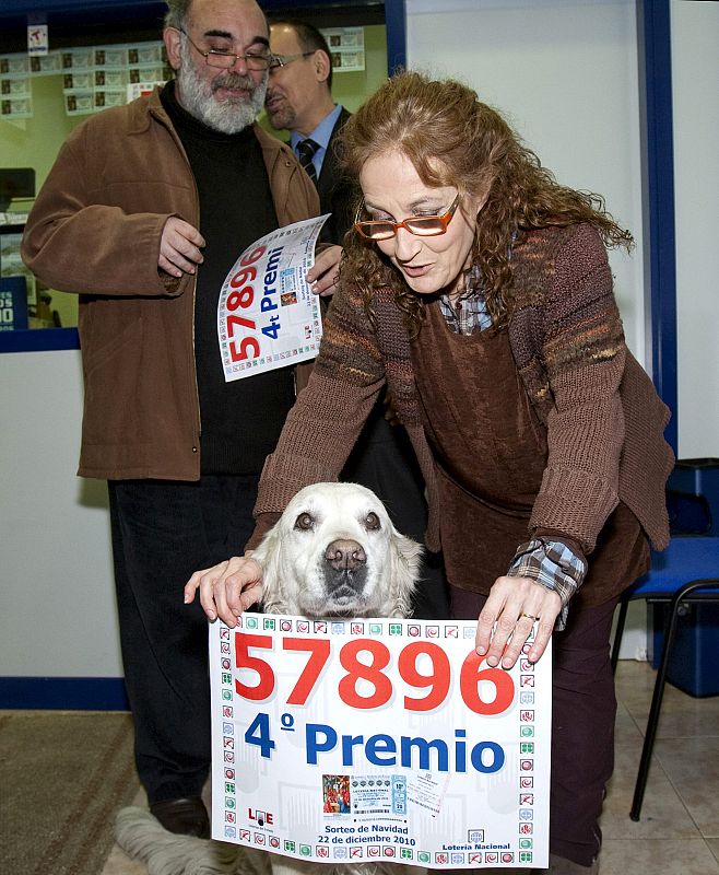 La propietaria de la administración Nº 271 de Barcelona, María Angels, muestra con su perro el número 57.896, premiado con el cuarto premio de la Lotería de Navidad