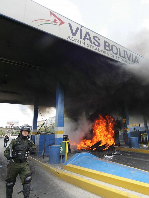 Policías bolivianos llegan al lugar de un incendio provocado por manifestantes en el peaje de la autopista que une a las ciudades bolivianas de El Alto y La Paz