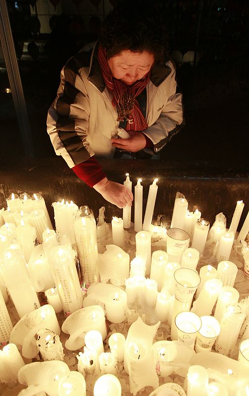 Una mujer enciende una vela en un templo budista de Seúl tras la llegada del 2011