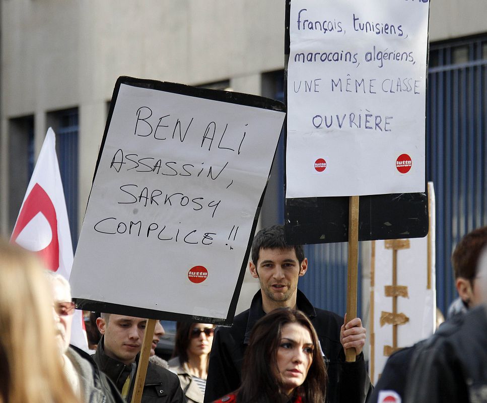 French supporters of Tunisian people hold a banner which reads "Ben Ali murderer, Sarkozy accomplice" as they demonstrate in Lyon