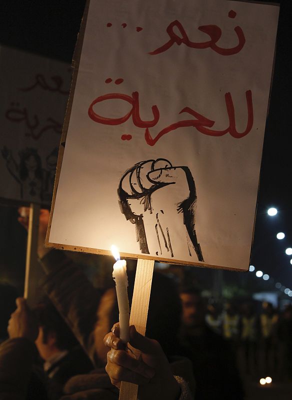 Syrian and Palestinian activists hold candles and banners during a candlelight in support of the protests in Egypt in front of the Egyptian embassy in Damascus