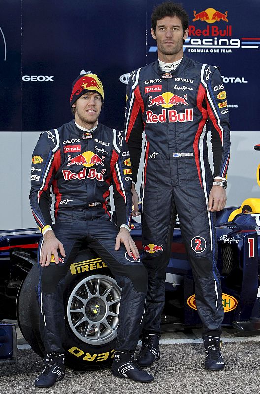 Los pilotos del equipo Red Bull de Fórmula Uno, el campeón del Mundo el alemán Sebastian Vettel, y el australiano Mark Webber, posan con el monoplaza RB7 para 2011.