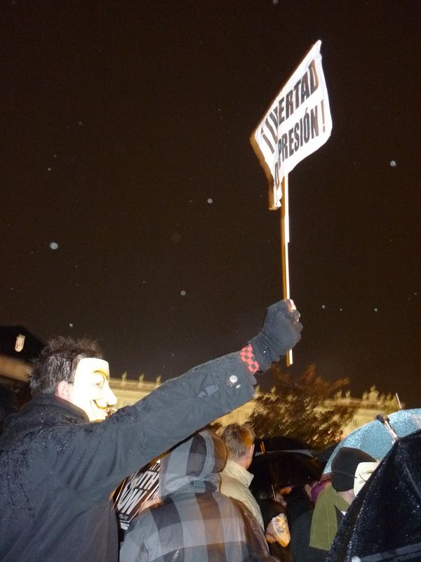 Un manifestante, con la careta de 'V de Vendetta', con un cartel en el que exige "libertad de expresión" durante la Operación Goya convocada por 'Anonymous'